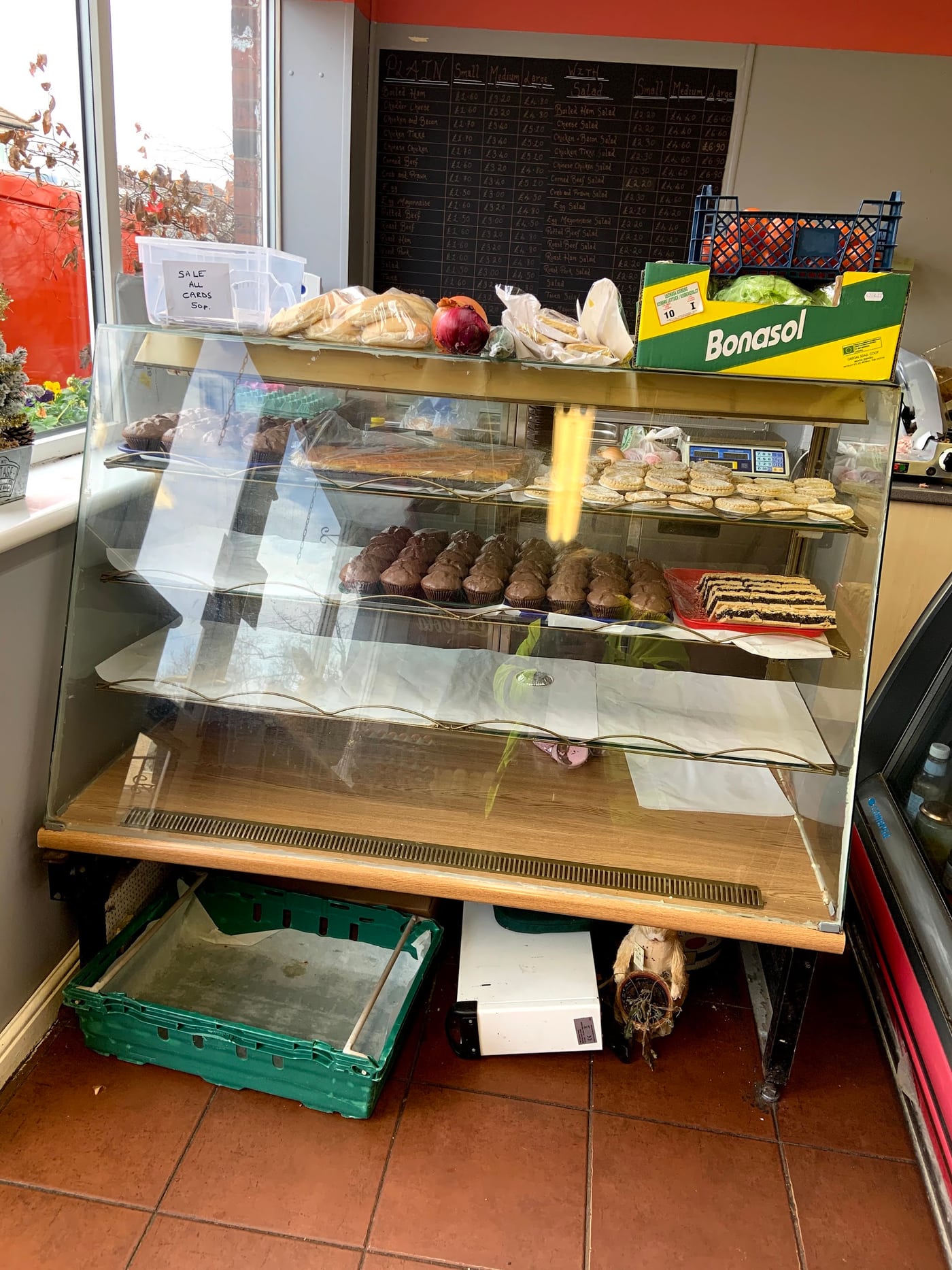 Moores counter with cakes, bread and the sandwich chalkboard